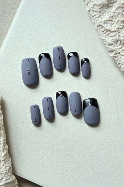 After Midnight matte blue-grey press-on nails with glossy black French tips and crystal details