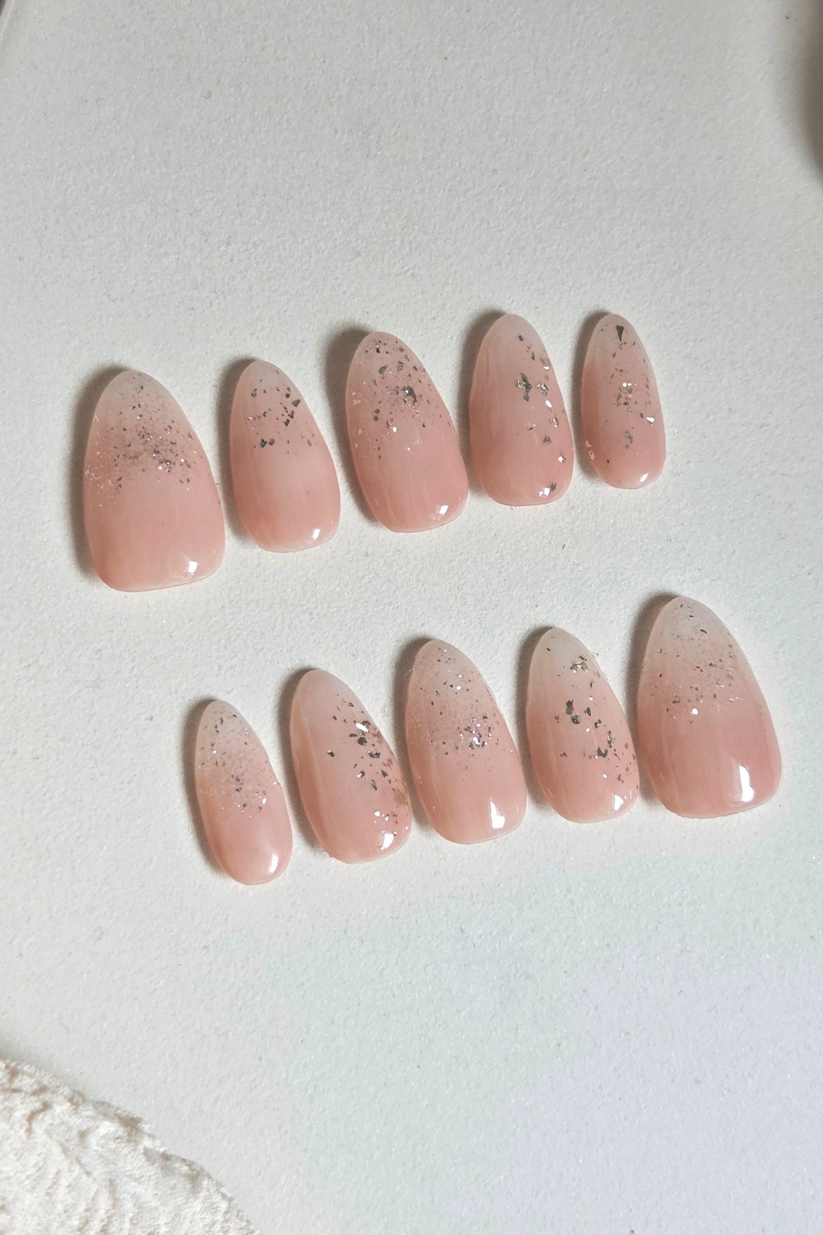 Soft blush pink press-on nails with delicate silver foil and subtle sparkle. Handmade, reusable and available in your choice of shape and size.
