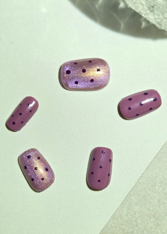 Shop Mulberry Muse by Rosie Posie — hand-painted mauve and mulberry press-on nails with rose-gold shimmer and delicate polka dots. Removable and reusable.