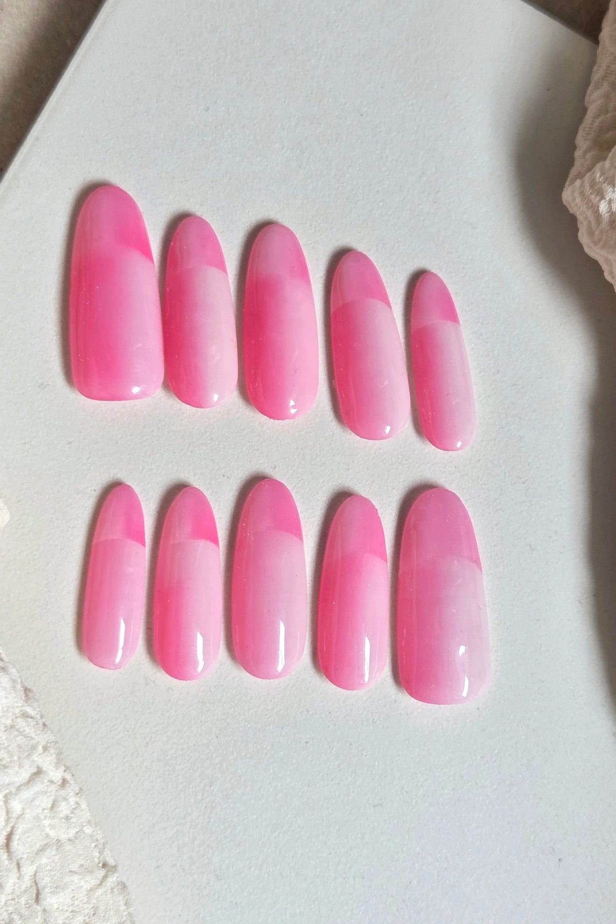 Bright pink and soft blush press-on nails with a modern colour-block design. Handmade, reusable and available in your choice of shape and size.
